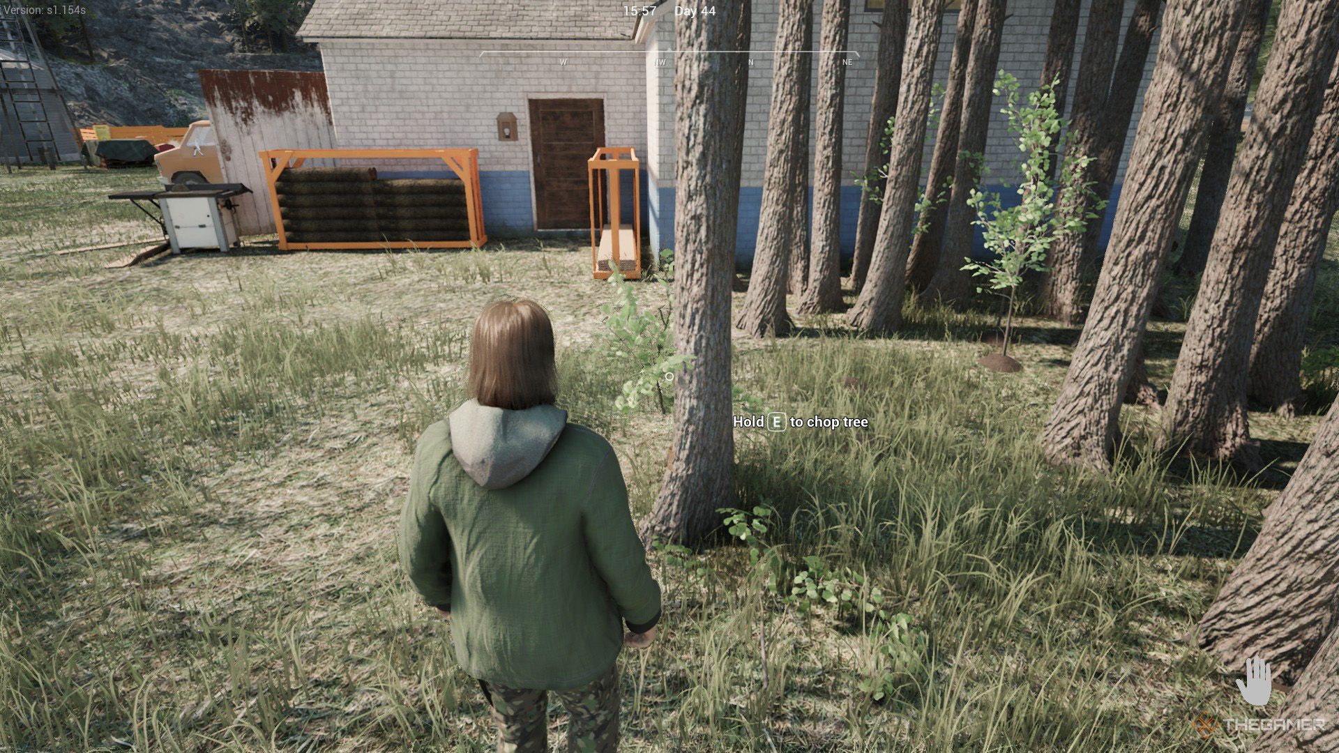 The player stands next to the fully grown trees next to a building in Ranch Simulator