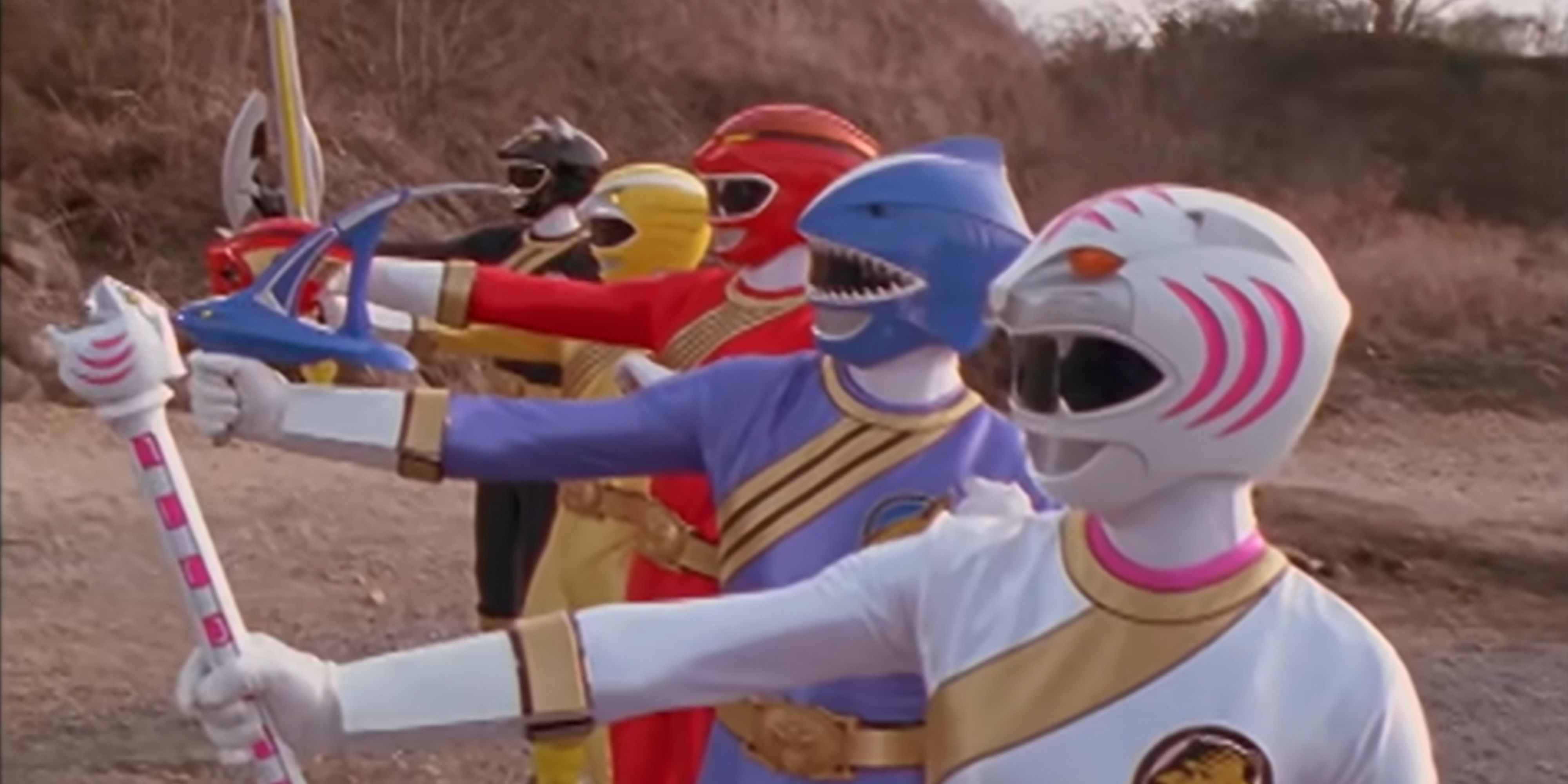 The Wild Force Power Rangers pose with their weapons.