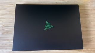 Razer Blade 16 gaming laptop closed on a wooden desk