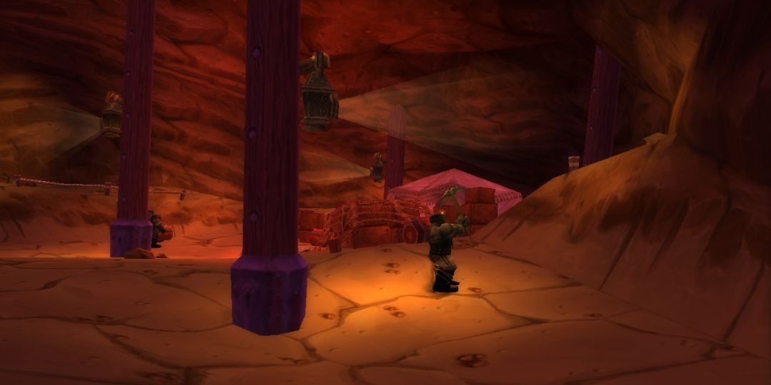 A dwarf mines in the dark red caverns of Uldaman.