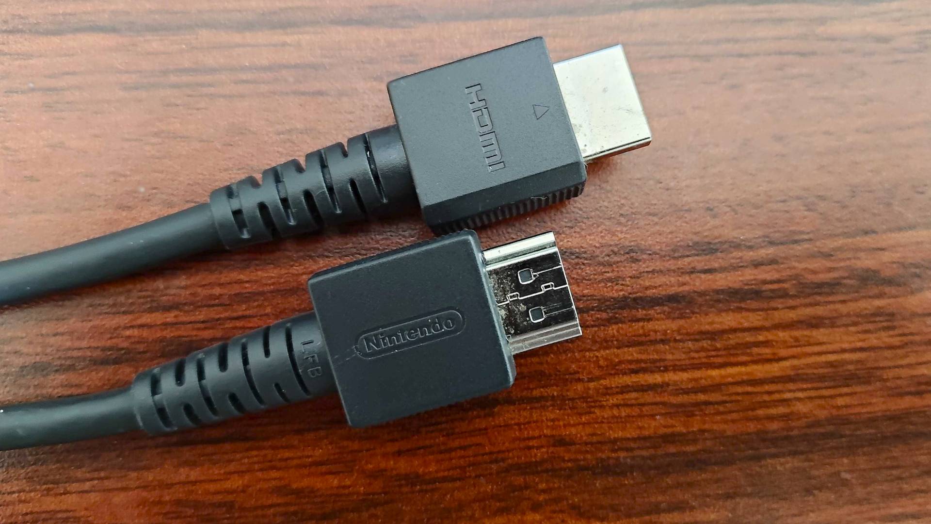 Original Switch HDMI cable on woodgrain desk.