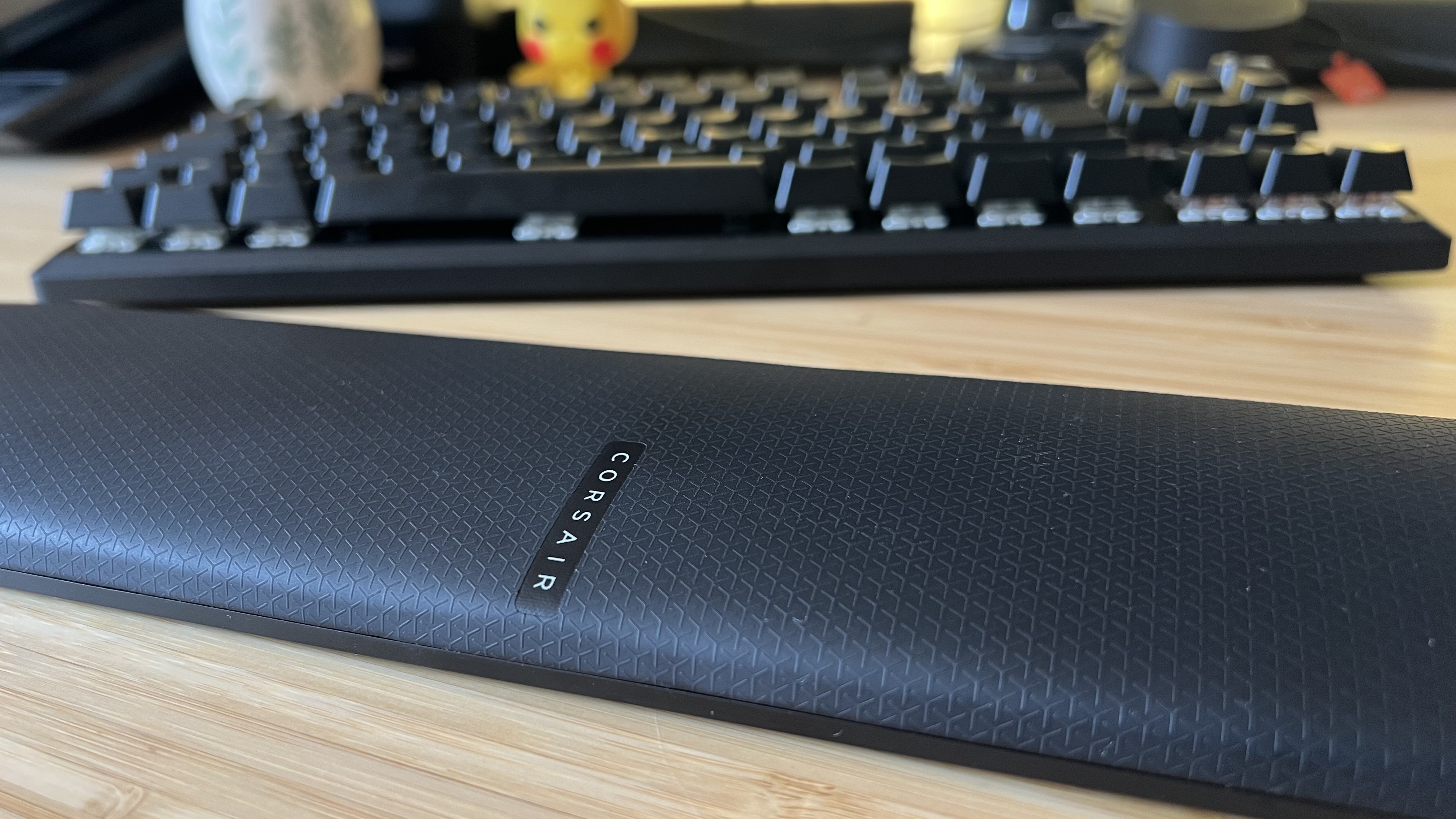 Close up on wrist rest of the Corsair K70 Pro TKL gaming keyboard on a wooden desk