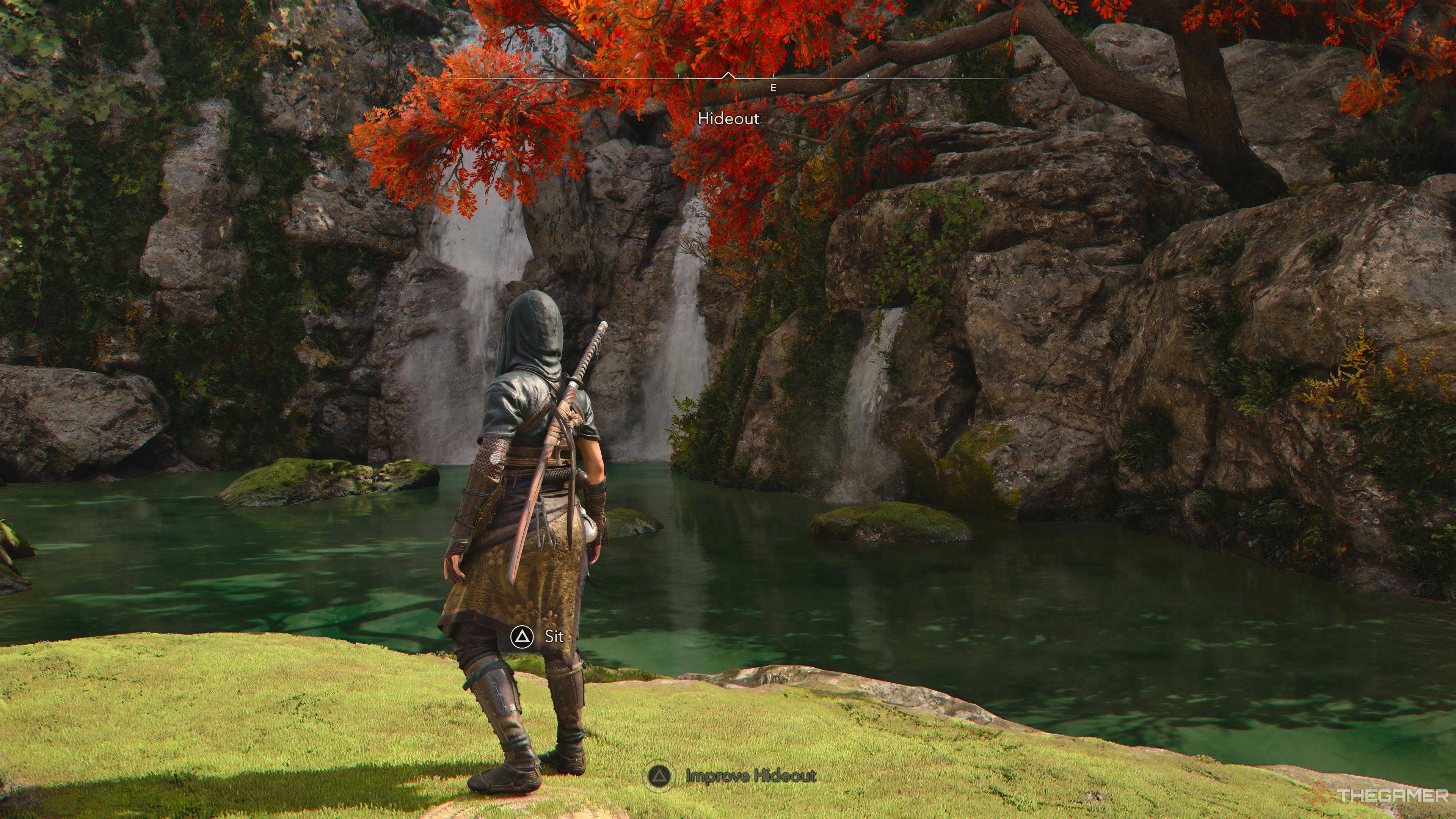 Waterfalls in the hideout base with a tree leaning over the lake in Assassin's Creed Shadows.