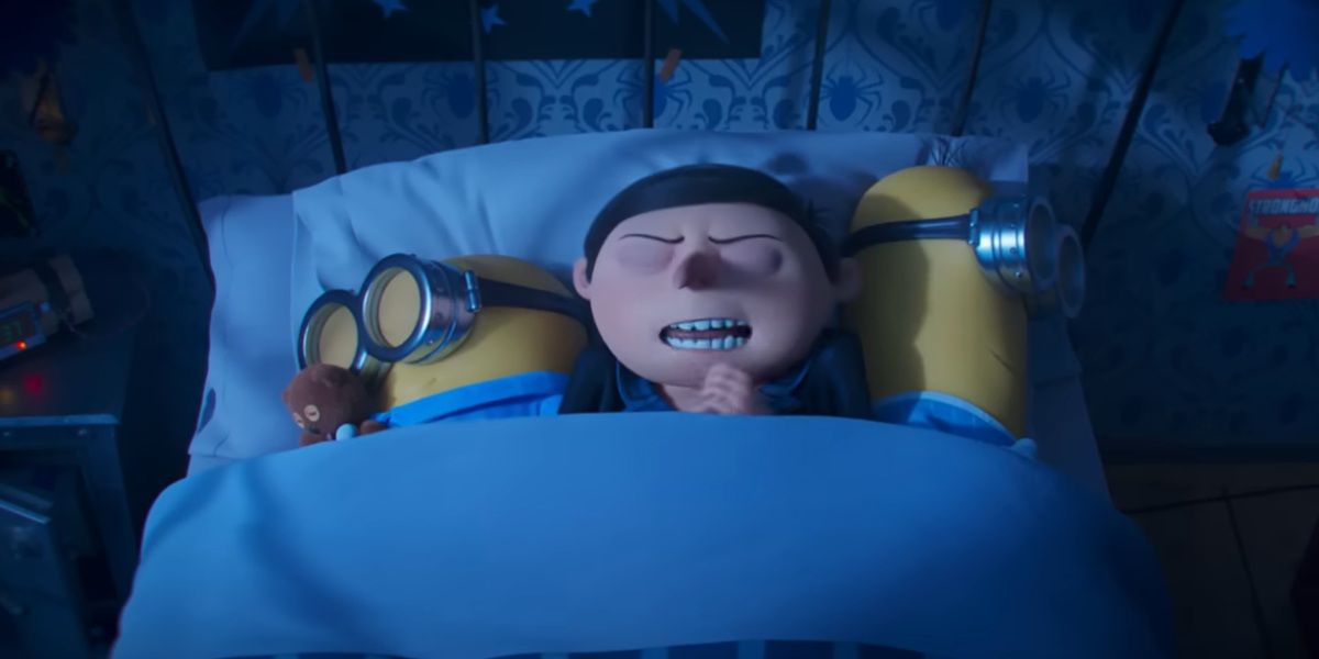 Young Gru lying in bed next to Minions in Minions: The Rise Of Gru.