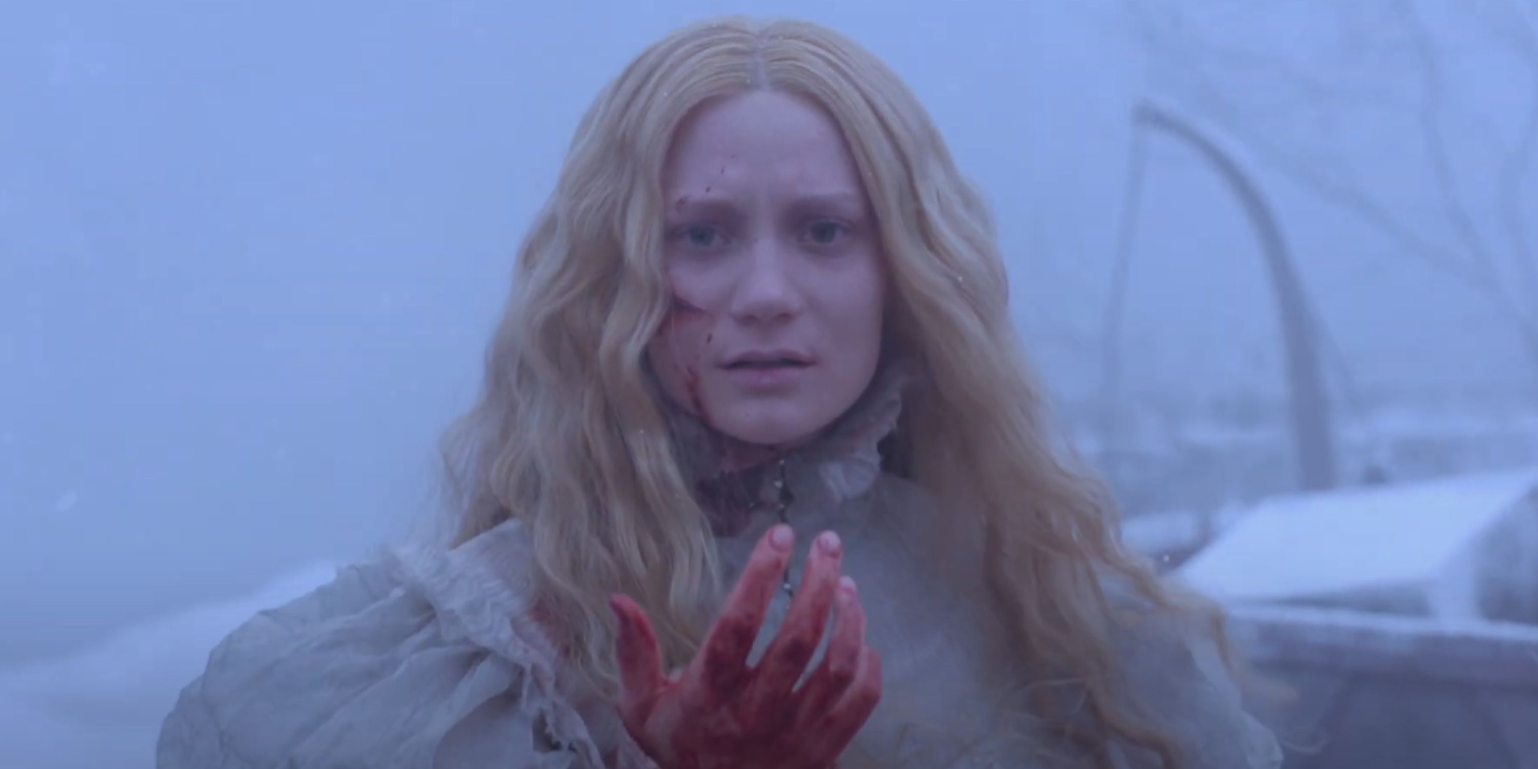An injured Edith lifts her bloodied hand.