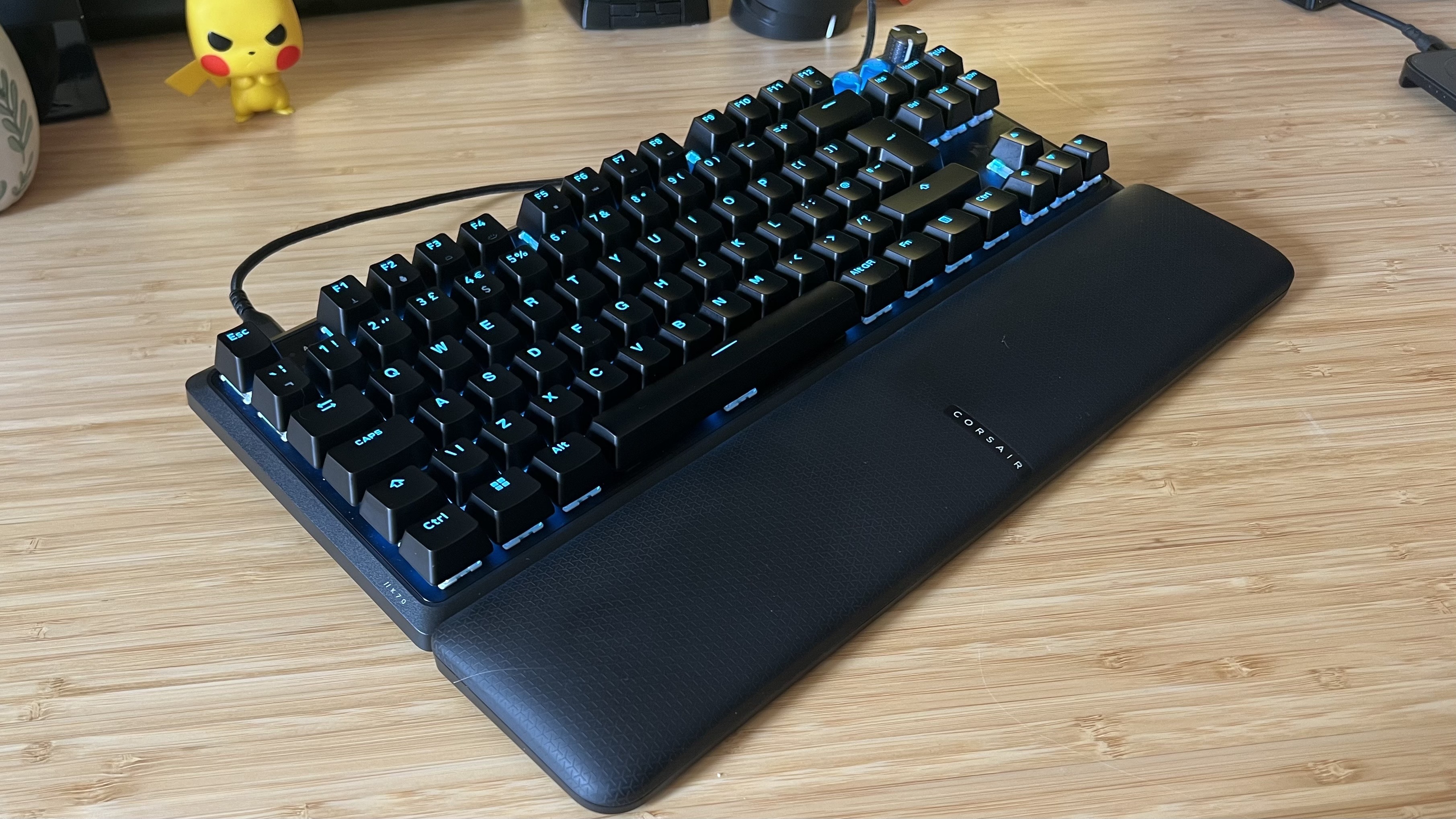 Corsair K70 Pro TKL gaming keyboard with wrist rest attached on a wooden gaming desk