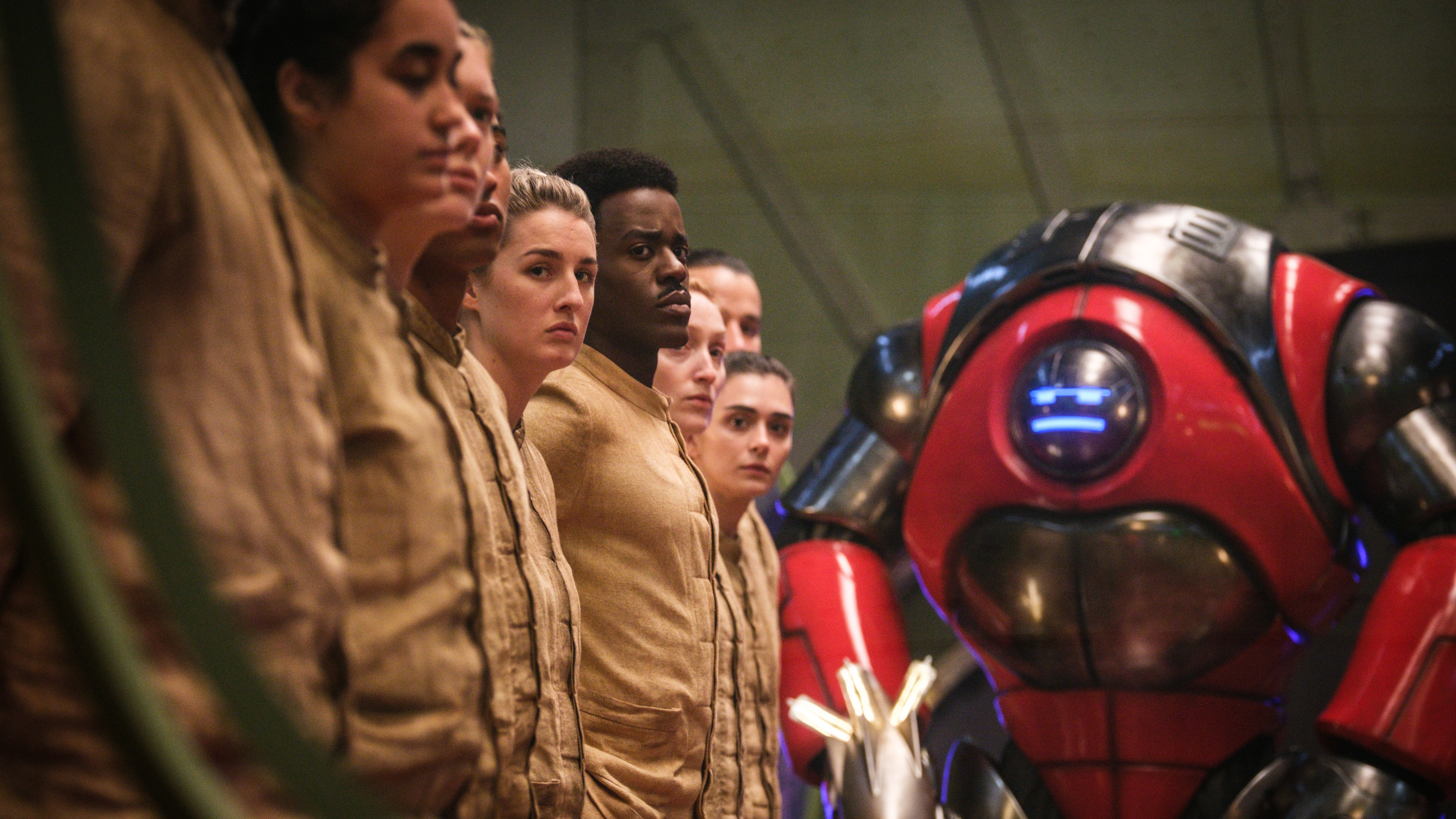 The Doctor and several humans are menace by a robot in Doctor Who: The Robot Revolution.