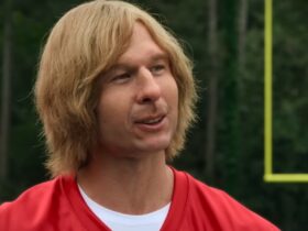 Glen Powell under make up as on a football field