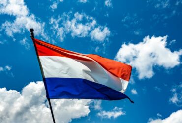 Netherlands flag with a blue sky background