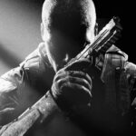 Key art for Call of Duty Black Ops 2 showing a character sitting in darkness with a handgun, from Edge 353
