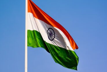 India flag blowing in wind with blue sky in background