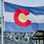 Colorado Flag flying in Glenwood Springs, CO, with mountains in the background