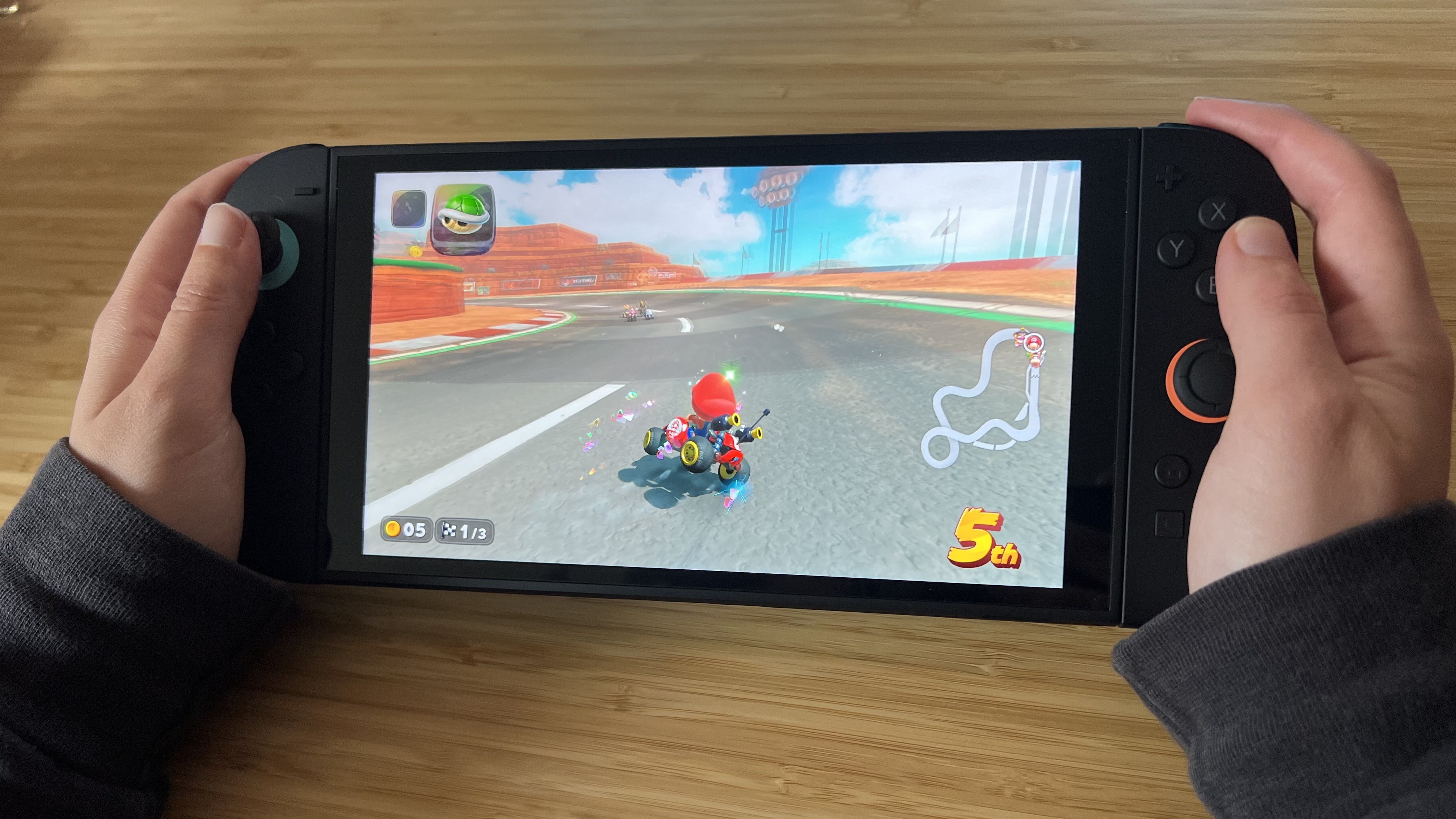 Hands holding Nintendo Switch 2 and playing Mario Kart World