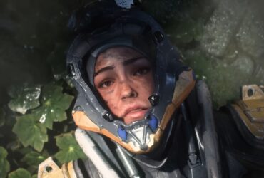 Screenshot of Anthem machine pilot lying on the leafy ground with visor open